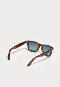Ochelari de soare cu model țestoasă, cu lentile degradient albastru închis, ramă rectangulară și textură netedă. Prezintă detalii metalice cu logo pe lateral.