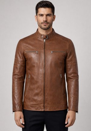 Man wearing a brown leather jacket with zippered chest and side pockets, standing against a plain light background.