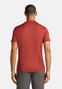 Rød kortærmet T-shirt med rund hals, lavet af letvægtsstof, har en subtil tekstur og en afslappet pasform samt synlige sømdetaljer.