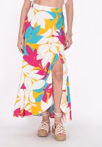 Maxi nederdel i klare farver med et blomsterdesign i turkis, gul og pink. Sideslids og let svævende stof; parret med kilehæle.