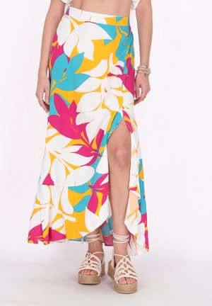Fustă maxi în culori vii cu un model floral ce include turcoaz, galben și roz. Cu o deschidere pe lateral și material fluid; asortată cu sandale cu talpă înaltă.