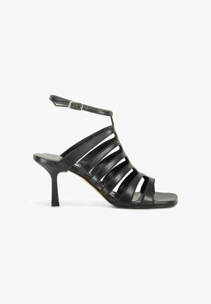 Sandale en cuir noir avec brides, boucle à la cheville, bout ouvert et talon kitten de hauteur moyenne sur fond blanc.