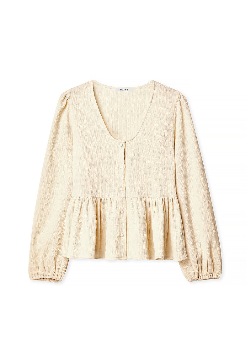 Kreeminvärvuline peplum blouse, mis on valmistatud tekstuurilisest kangast, omab sügavat ümmargust kaelust, pikki puffvarrukaid ja pearl-sarnaseid nuppe.