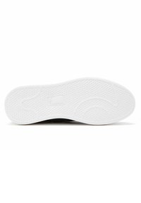 Sneaker nera con suola in gomma bianca caratterizzata da motivi di grip testurizzati e un bordo liscio. Il design è a profilo basso e minimalista.