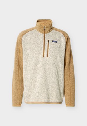 Fleece-Pullover für Herren mit Farbblock in Beige und hellem Braun, Reißverschluss vorne bis zur Mitte der Brust, Reißverschlusstasche auf der Brust und Patagonia-Logo auf der Brust.