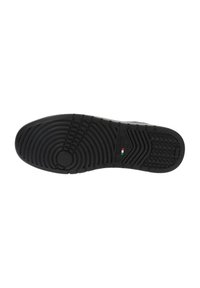Semelle de chaussure en caoutchouc noir avec des motifs de crampons circulaires et linéaires, dotée d'un petit accent avec le drapeau italien. Texturée pour une adhérence et une traction optimales.