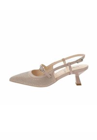 Chaussure slingback beige à bout pointu avec petit talon, clous décoratifs à l'avant et brides réglables avec boucles sur le pied et la cheville.