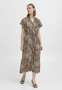 Leopardmönstrad klänning i ett slätt tyg, med korta ärmar, v-formad halsringning, dragsko i midjan och en flödande, knälång kjol.