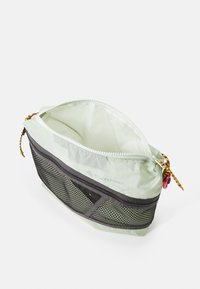 Light green zippered pouch with a mesh lower section, integrated drawstring, and a small accent loop for attachment. Smooth texture.