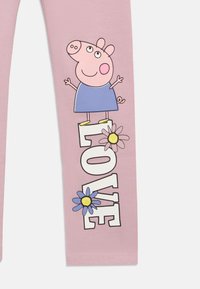 Różowe leginsy z rysunkową postacią świnki „Peppa Pig” w niebieskiej sukience; tekst „LOVE” napisany pogrubioną czcionką z kwiatami obok. Gładka faktura.