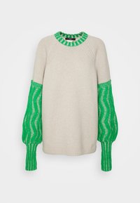 Cremfarbener Pullover mit voluminösen grünen Strickärmeln im Wellenmuster und einem gerippten Ausschnitt. Weicher Stoff mit lockerer Passform.