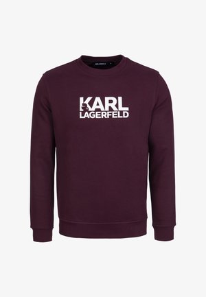 Bordeaux sweater met lange mouwen, ronde hals en het witte "KARL LAGERFELD" logo prominent op de voorkant weergegeven. Zachte stoftextuur.