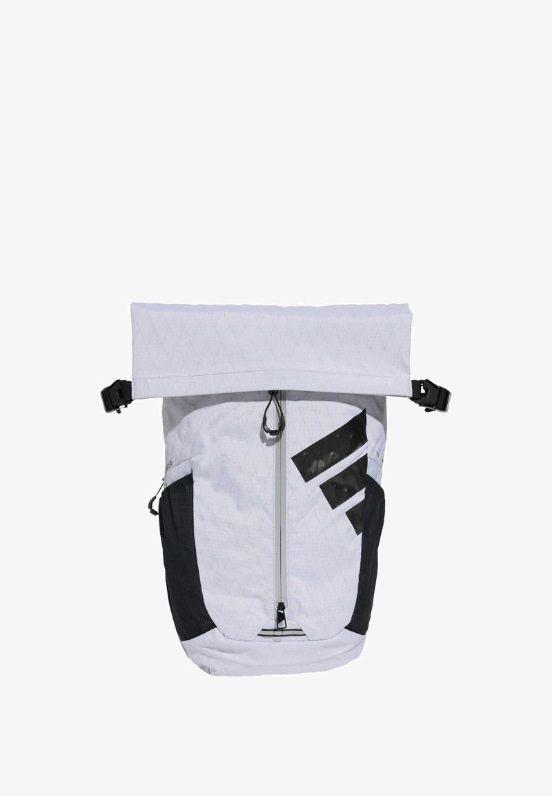 Mochila con una tela de patrón de diamantes blancos y una zona de acento negra. Cuenta con un cierre enrollable y un bolsillo frontal con cremallera.