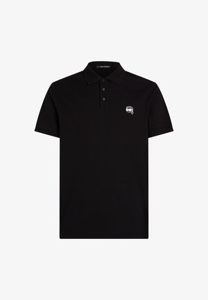 Must must on t-särgid, mis on valmistatud puuvillast, millel on kolme nööbiga kaelus, lühikesed varrukad ja väike brodeeritud logo vasakul rinnal.