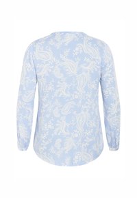 Blouse à manches longues bleu clair présentant un motif cachemire et floral blanc, avec un col rond et des détails froncés aux poignets.