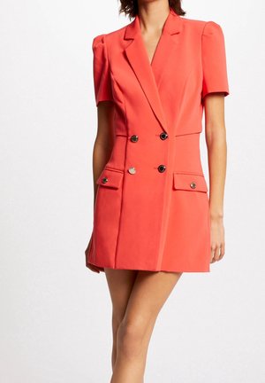 Koronkowa dwurzędowa sukienka w kolorze koralowym z krótkimi rękawami, z dwoma przednimi kieszeniami, metalowymi guzikami, usztywnionymi ramionami i dopasowaną sylwetką.