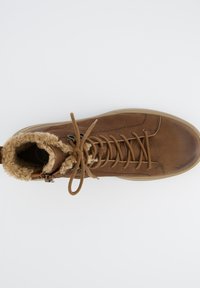Bruine leren laars met een zachte, tekstuurvolle vachtkraag, ronde teen en stevige veters. Ontworpen voor comfort en warmte.