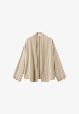 Chaqueta beige de frente abierto con mangas largas y sutiles detalles de costura a lo largo de los bordes frontales y los puños de las mangas.