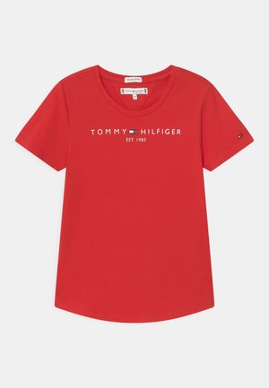 T-shirt rouge à manches courtes Tommy Hilfiger avec col rond et texte de logo blanc "Tommy Hilfiger Est. 1985" sur le devant.