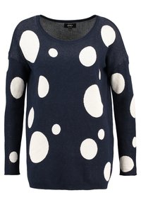 Navy blue sweater with long sleeves, features large white circular patterns, round neckline, and a loose fit.