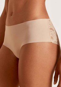 Beige hipster boxers gemaakt van gladde stof, met een fijne kanten inzet aan de zijkant, naadloze randen en een uitstekende pasvorm.