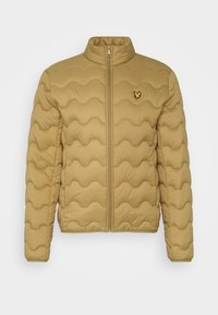 Chaqueta acolchada de color marrón claro con un patrón de costura en forma de ondas, cierre de cremallera en la parte delantera, cuello alzado y pequeño logotipo de un pájaro amarillo en el pecho.