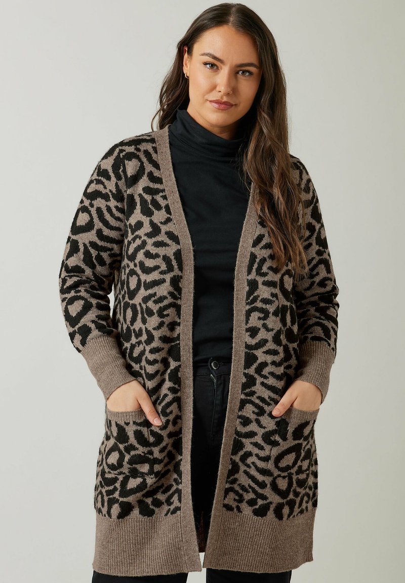 Läiskäripäinen neuletakki vaaleanruskeana ja mustana, valmistettu pehmeästä neulemateriaalista. Ominaisuuksiin kuuluu pitkä malli, avoin etuosa ja kaksi etutaskua.