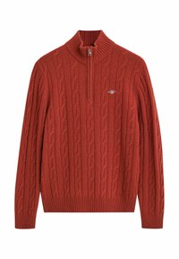 Roestkleurige trui met een hoge ribbelsluiting, halve rits en kabelbrei-textuur. Voorzien van ribbelboorden en een ribbelzoom.