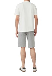 T-shirt en coton blanc, shorts en denim gris, et chaussures décontractées. Les shorts ont une coupe régulière avec des poches. Pas de motifs ni de détails décoratifs.