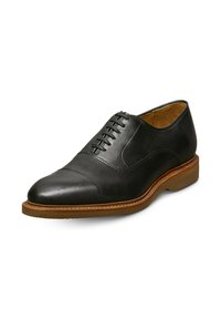 Scarpe Oxford in pelle nera con una superficie liscia, design a punta carioca, suola a contrasto color cuoio e dettagli con lacci sulla parte superiore.