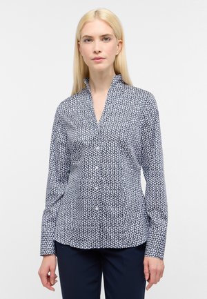 Chemise boutonée bleu marine avec un motif abstrait blanc, dotée d'un col cantonnais et de manches longues, fabriquée dans un tissu lisse.