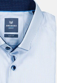 Hellblau gestreifte Hemdbluse mit schlanker Passform. Verfügt über einen weichen Kragen, ein dunkelblaues gemustertes Innenfutter und dunkle Knöpfe. Markenlabel sichtbar.