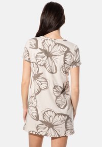 Kurzärmeliges Kleid aus beigem Baumwollstoff mit großem braunem Schmetterlingsmuster, abgerundetem Ausschnitt und lockerem Schnitt, der oberhalb der Mitte des Oberschenkels endet.