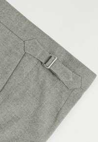 Herringbone-patterned gray fabric featuring a belt loop with a silver metal buckle, showcasing a textured woven design and sharp edges.