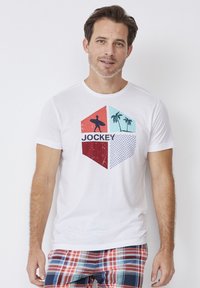 White cotton t-shirt featuring a graphic print with four colored sections: red, light blue, dark blue, and beige, depicting surf and palm tree motifs.