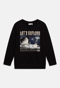 Sudadera negra con un diseño gráfico de planetas, una casa y el texto "VAMOS A EXPLORAR" en una fuente crema en negrita. Tejido suave y texturizado.