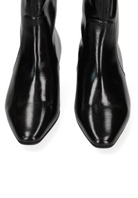 Bottines noires en cuir avec une finition brillante, bout pointu et design sans couture. Offre un ajustement parfaitement ajusté avec un minimum de matériel.