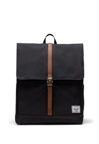 Svart tygryggsäck med läderremmar, kvadratisk form, toppklaffstängning och en liten logotyp-patch på framsidan.