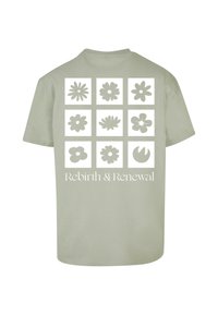 Lyse olivengrøn bomulds T-shirt med ni blomsterdesigns på ryggen, med teksten "Genfødsel & Fornyelse" nederst.