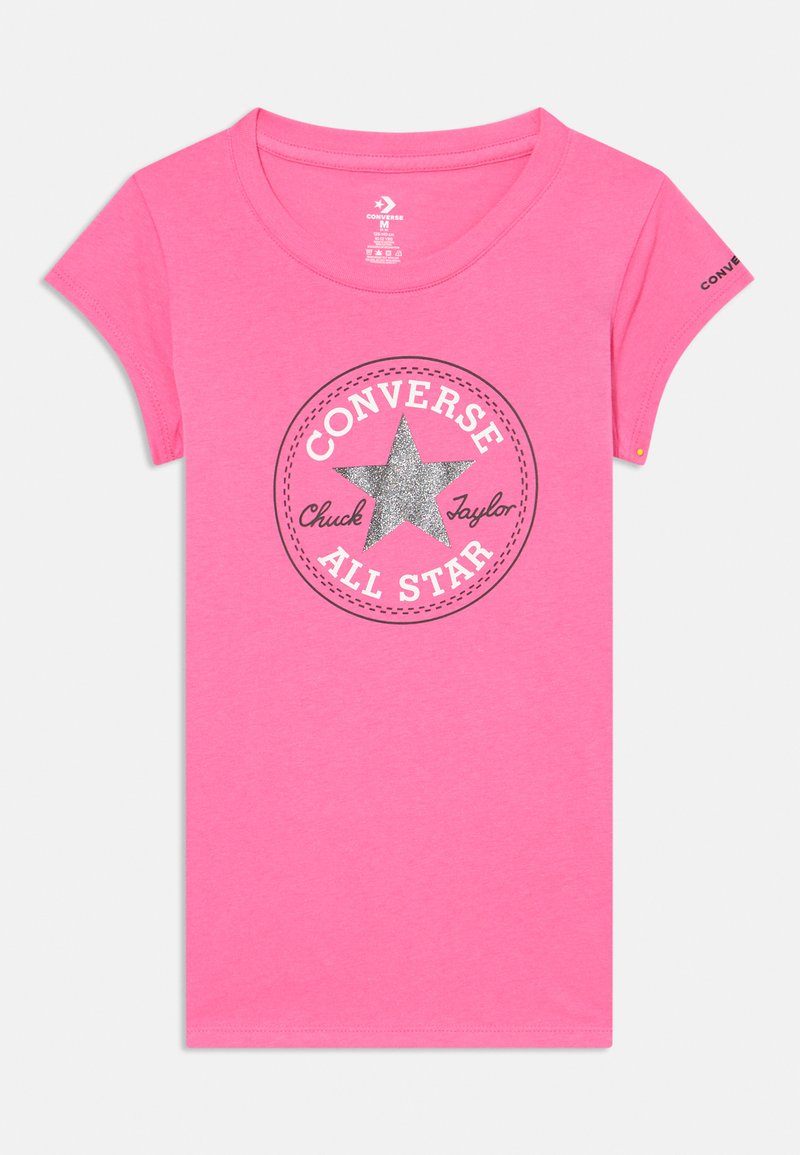 T-shirt en coton rose à manches courtes avec un graphique circulaire arborant une étoile argentée et le texte "Converse Chuck Taylor" en noir autour.