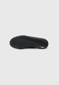 Fekete sportcipő talp, textúrált gumimintázattal, világoskék akcentussal és egy kis Nike logóval.