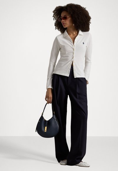 White long-sleeve button-up shirt with collar, navy wide-leg trousers, and a dark blue textured handbag with gold accents. Sunglasses complete the look.