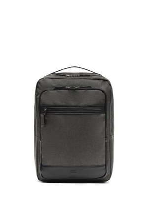 Tummanharmaa suorakaiteen muotoinen reppu, jossa useita vetoketjullisia lokeroita ja yläpuolella kantokahva, valkoista taustaa vasten.