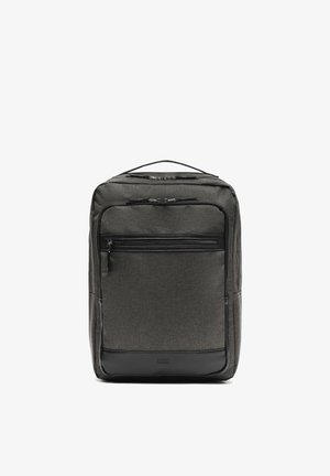 Sac à dos rectangulaire gris foncé avec plusieurs compartiments zippés et une poignée de transport sur le dessus, présenté sur un fond blanc uni.