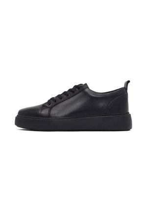 Zwarte leren lage sneaker met veterluiting aan de voorkant en dikke rubberen zool, zijaanzicht op een witte achtergrond.