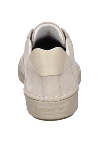 Zapatilla de ante beige con un diseño redondeado, cuello acolchado y un acento en el talón de textura suave. Logo en la parte trasera. Suela de goma plana.
