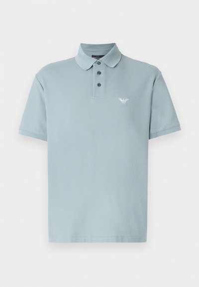 Light blue polo shirt in soft cotton. Features a collar, three-button placket, short sleeves, and a small logo on the left chest.