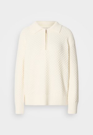 White knit pullover with a textured pattern, half zipper, and ribbed collar and cuffs. The material appears soft and cozy.