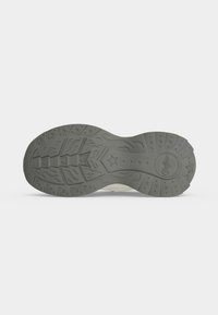 Semelle de chaussure avec motif de bande de roulement en forme d’étoile, dessins ondulés et géométriques, et nom de marque embossé sur une surface en caoutchouc gris.