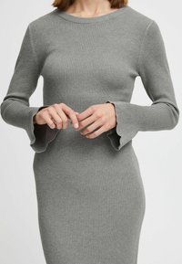 Abito grigio a maniche lunghe con righe, scollatura rotonda e polsini svasati, caratterizzato da una silhouette aderente e una morbida lavorazione a maglia.